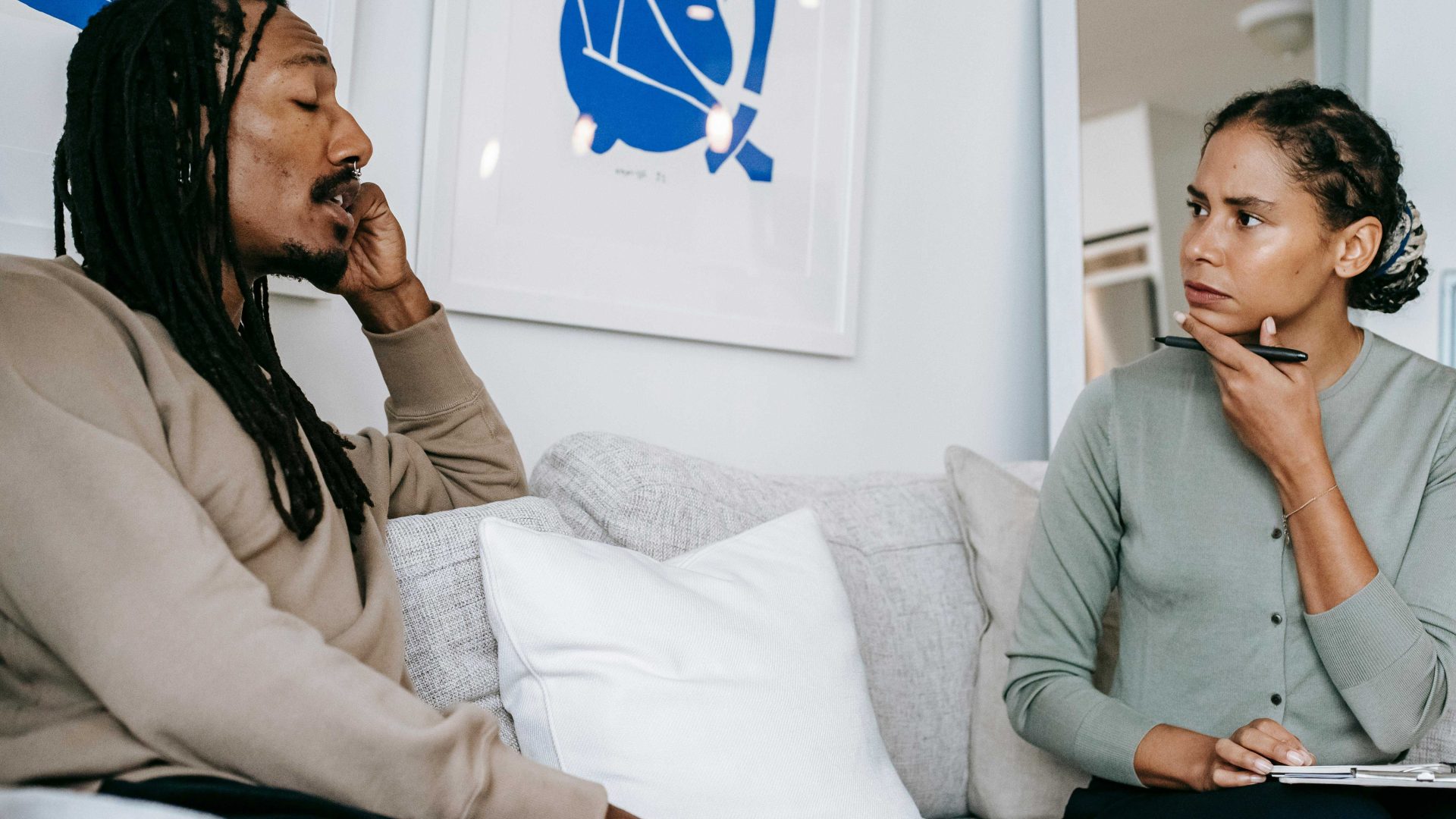 Two people sitting on a sofa chatting deep in thought