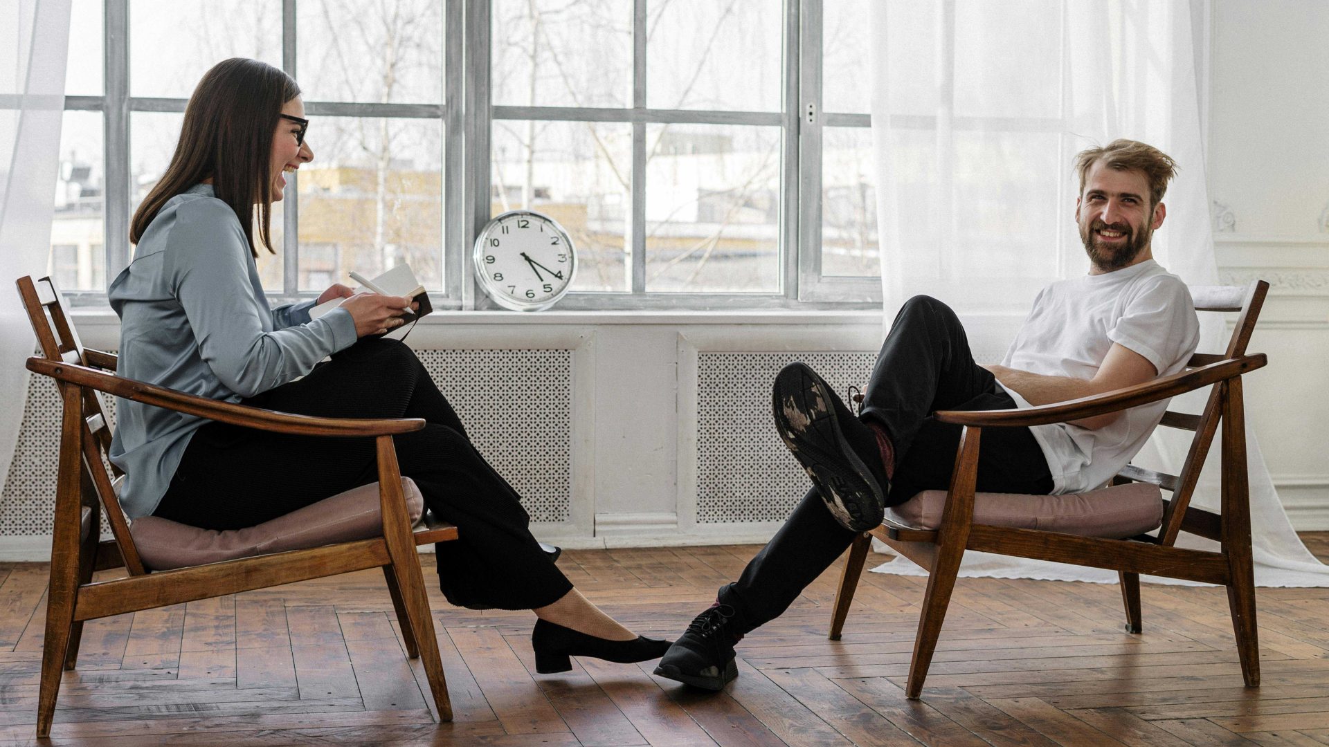 Two people sitting opposite each other chatting and smiling