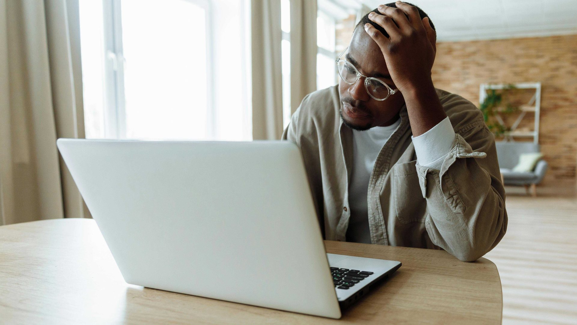 Person with head resting on hand looking at computer screen
