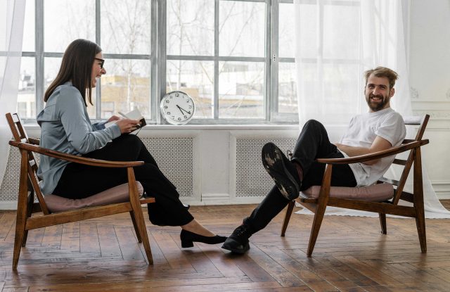 Two people sitting opposite each other chatting and smiling