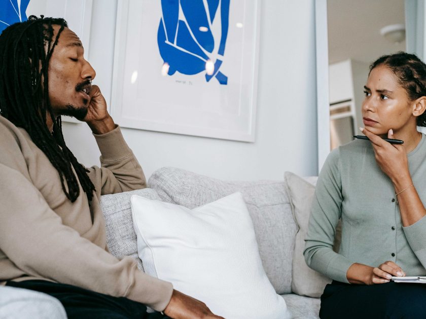 Two people sitting on a sofa chatting deep in thought