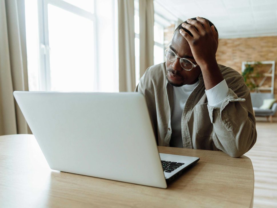 Person with head resting on hand looking at computer screen